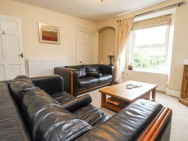 A living room with a sofa and coffee table at Sygun Cottage in Nant Gwynant
