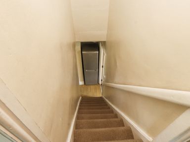 A staircase leading to a fridge at Sygun Cottage in Nant Gwynant