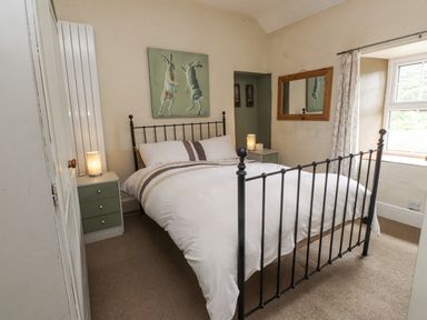 A bedroom with a bed and bedside table at Sygun Cottage in Nant Gwynant
