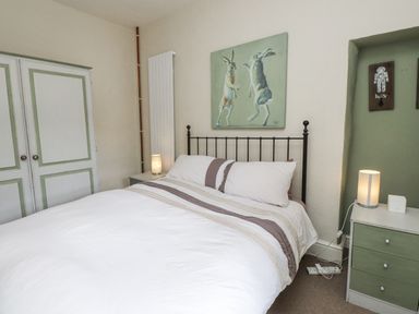 A bedroom with a bed and wardrobe at Sygun Cottage in Nant Gwynant
