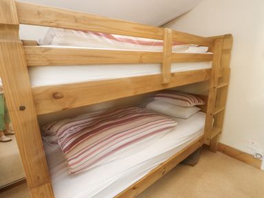 A bunk bed with pillows and mattresses at Sygun Cottage in Nant Gwynant