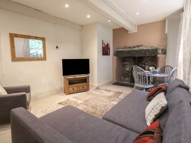 A living room with a TV and a dining area at Tryfan Cottage in Nant Gwynant
