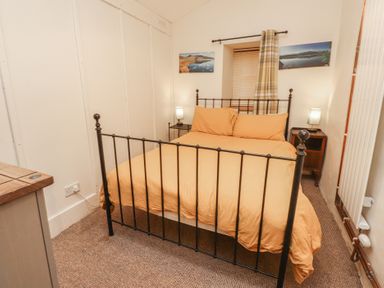 A bedroom with a bed and nightstand at Tryfan Cottage Nant Gwynant