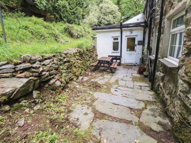 An outdoor area with a stone path and seating at Tryfan Cottage in Nant Gwynant