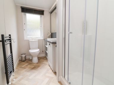 A bathroom with a toilet sink vanity and shower at 16 Manleigh Park in Combe Martin
