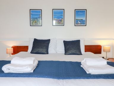 A bed with pillows and artwork on the wall at Nanvivian Feock near Truro