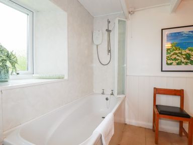 A bathroom with a bathtub and shower at Nanvivian Feock near Truro