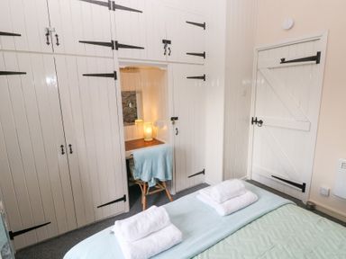 A bedroom with a bed and cupboards at 8 Rogeston Cottages Haverfordwest