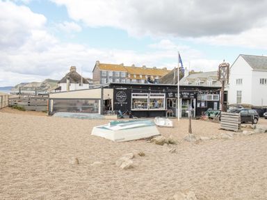 An outdoor café with boats on gravel at Flat 13, Chesil House in Bridport