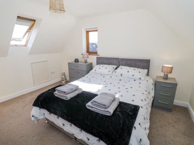 A bedroom with a double bed flanked by two bedside tables with lamps at Little Barn Dodwell near Stratford-Upon-Avon