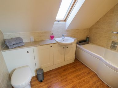 A bathroom with a bathtub toilet sink and countertop with towels and soap at Little Barn in Dodwell near Stratford-Upon-Avon