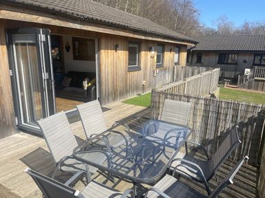 An outdoor patio with a table and chairs at Woodburn Lodge in Otterburn