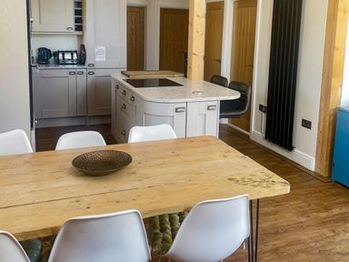 A kitchen with a dining table and chairs at Woodburn Lodge, Otterburn