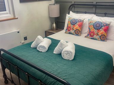 A bedroom with a bed and decorative pillows at Woodburn Lodge Otterburn