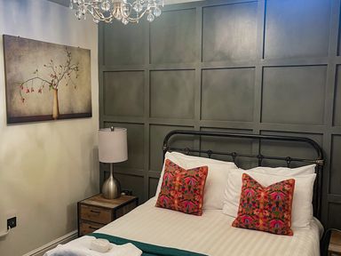 A bedroom with a bed and nightstand at Woodburn Lodge in Otterburn