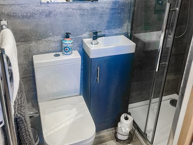 A bathroom with a toilet, sink, and shower at Woodburn Lodge in Otterburn