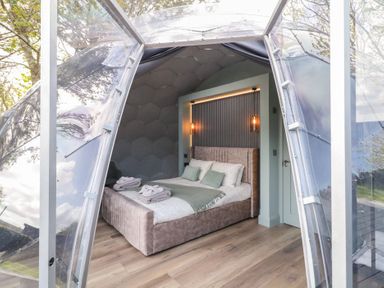 A bedroom inside a transparent dome structure with a bed and folded towels at Number 1 Dome in Derrybeg County Donegal
