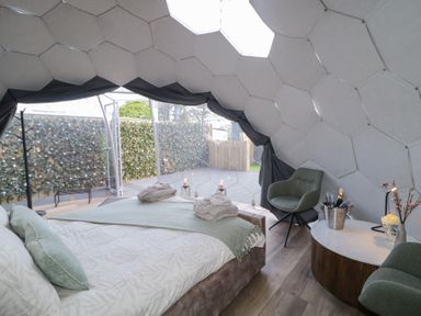 A bedroom inside a dome with a bed robes and chairs at Number 1 Dome in Derrybeg County Donegal