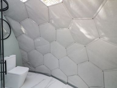 A bathroom with a toilet and hexagonal padded wall at Number 1 Dome in Derrybeg County Donegal