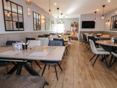 A dining area with tables and chairs and mirrors on the wall at Number 1 Dome in Derrybeg County Donegal