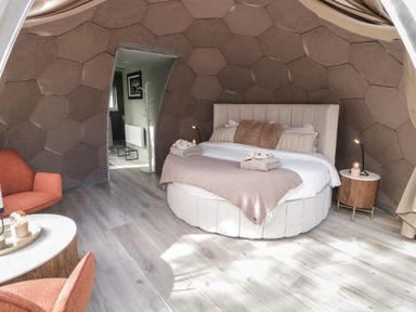 A bedroom with a round bed two side tables and two chairs at Number 2 Dome in Derrybeg County Donegal