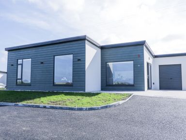 A modern single-story house with large windows a driveway and a garage at Number 5 Villa - The View in Derrybeg County Donegal