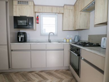 A kitchen with built in oven stove microwave and cabinets at HW42 in Bognor Regis