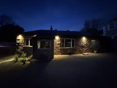 A house with lights on the exterior at Yew Tree Cottage Mealsgate near Ireby