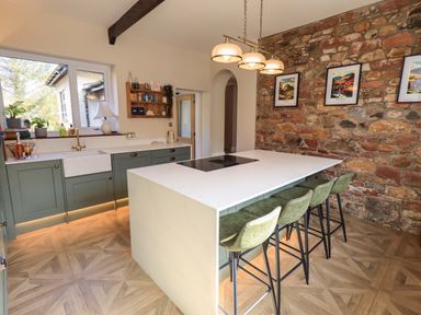 A kitchen with a sink and island at Yew Tree Cottage Mealsgate near Ireby