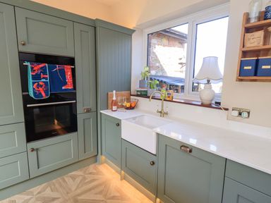A kitchen with a sink and cabinets at Yew Tree Cottage, Mealsgate near Ireby