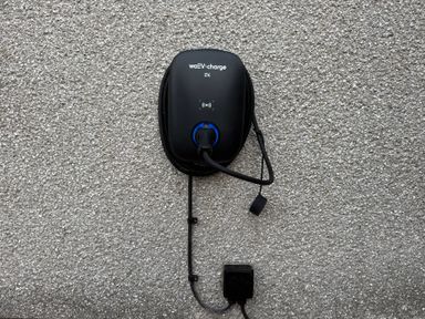 An electric vehicle charger mounted on a wall at Yew Tree Cottage in Mealsgate near Ireby