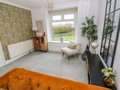 A living room with a sofa and lamp at Burry House in Llanmorlais