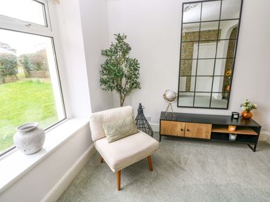 A living room with a plant and armchair at Burry House Llanmorlais