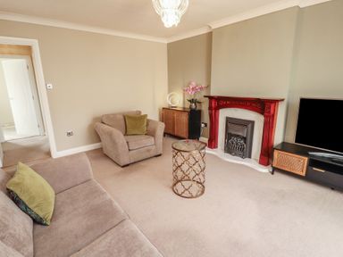 A living room with a sofa and fireplace at 3 Hawk Place Moresby Parks near Whitehaven