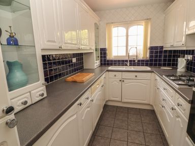A kitchen with a sink and gas stove at 3 Hawk Place in Moresby Parks near Whitehaven