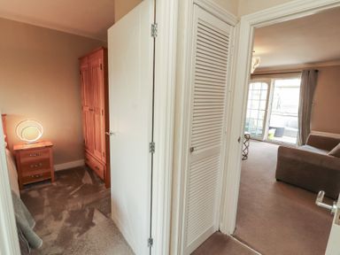 A hallway with a closet and lamp at 3 Hawk Place in Moresby Parks near Whitehaven