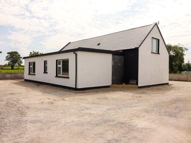 A house with a sloped roof and windows at Teach Ti in Miltown Malbay