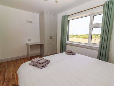 A bedroom with a bed and a wardrobe at Teach Ti in Miltown Malbay