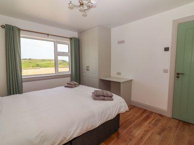 A bedroom with a bed and window at Teach Ti in Miltown Malbay