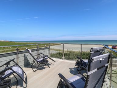 A deck with chairs overlooking the ocean at Life's a Beach in Bacton