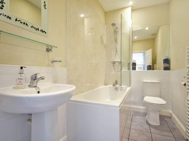 A bathroom with a sink toilet and bathtub with shower at Churchside in Alnwick