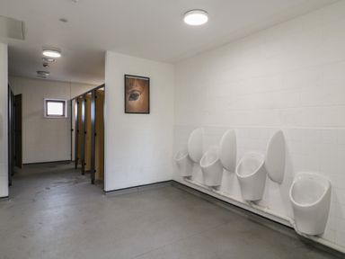 A men's restroom with five urinals and three toilet stalls at Buttercup (Cow Shed 3) in Easton near Campsea Ashe