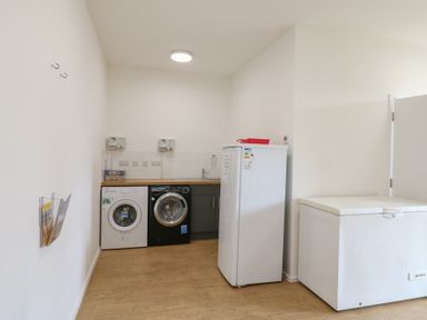 A utility room with a washing machine dryer fridge freezer at Dozy Dotty Cow Shed 4 Easton near Campsea Ashe