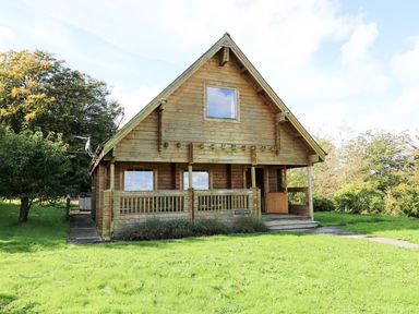 A wooden house with a porch and grass area at Pen Y Clawdd near Beggar's Bush Presteigne