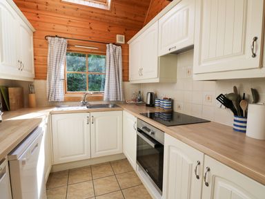 A kitchen with cabinets and a window at Pen Y Clawdd near Beggar's Bush near Presteigne