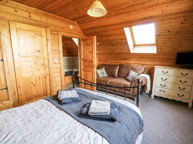 A bedroom with a bed and a sofa at Dan Y Coed in Beggar's Bush near Presteigne