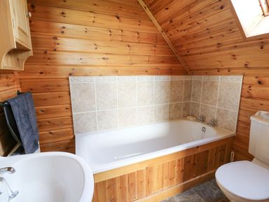 A bathroom with a bathtub and toilet at Dan Y Coed near Beggar's Bush near Presteigne
