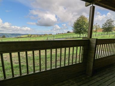 A view from a wooden terrace showing fields and trees at Dan Y Coed near Beggar's Bush