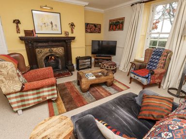 A living room with a fireplace and television at Elford Farmhouse, Seahouses