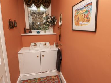A bathroom with sink and cabinet at Elford Farmhouse in Seahouses